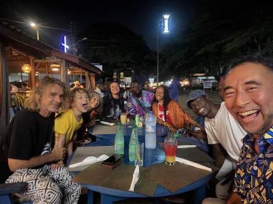 Dîner convivial en terrasse, ambiance nocturne béninoise