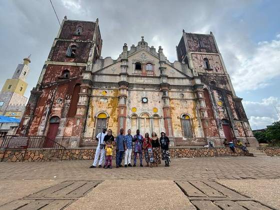 Groupe de voyageurs devant un édifice historique de Porto-Novo